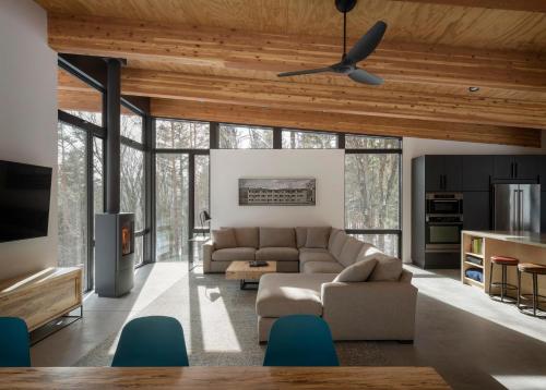 a living room with a couch and a ceiling fan at Sterling Treehouse in Stowe