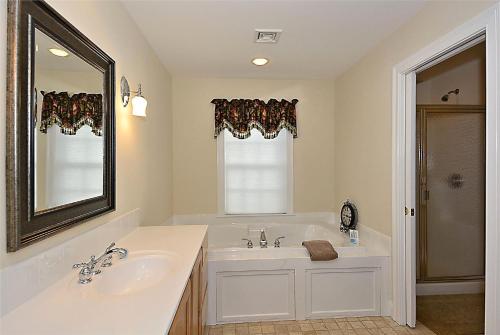 a white bathroom with a sink and a mirror at Village Stroll in Stowe