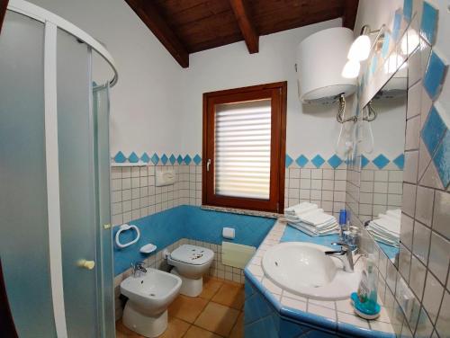a blue and white bathroom with a toilet and a sink at Il Fenicottero 2 in Masainas