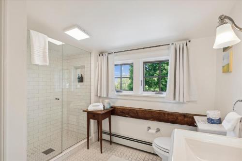 een badkamer met een douche, een toilet en een raam bij The Village Farmhouse in Stowe