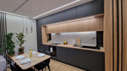 een keuken met een tafel met stoelen en een wastafel bij Apartament Proszowska 58A, Bochnia, 40 m2 z prywatnym miejscem postojowym in Bochnia