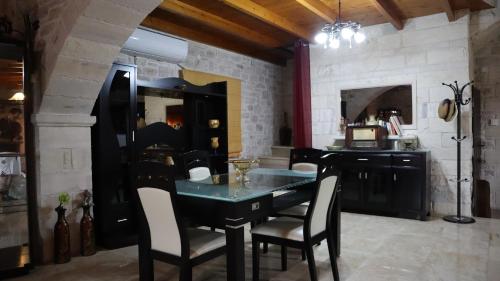 ein Esszimmer mit einem schwarzen Tisch und Stühlen in der Unterkunft Hephaestus Villa in Kapparianá