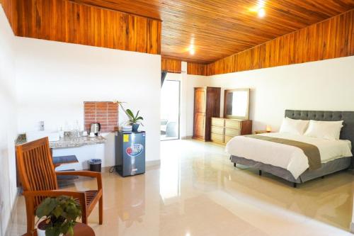 a bedroom with a bed and a kitchen in it at Hotel Ribera La Paz in Piedades Norte