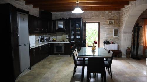 a kitchen with a table and chairs in a room at Petrini Villa with swimming pool in Kapparianá