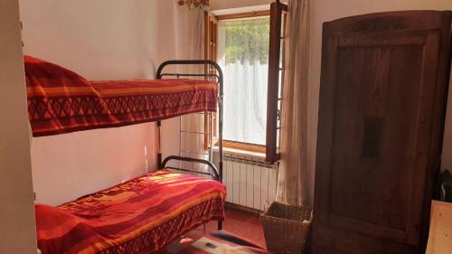 Roa MarencaにあるLa Casetta in Codevilla - Roburentの二段ベッド2台と窓が備わる客室です。