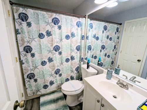 uma casa de banho com um WC e uma cortina de chuveiro em Luxurious Lakefront Retreat In Winterset em Winter Haven
