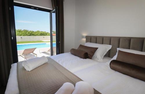 a bedroom with two beds and a view of a pool at Villa Gemini in Zadar