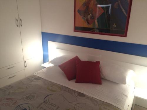 Un dormitorio con una cama con almohadas rojas. en KAMARINA RESORT, en Scoglitti