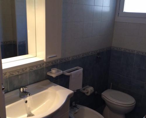 a bathroom with a sink and a toilet and a mirror at KAMARINA RESORT in Scoglitti