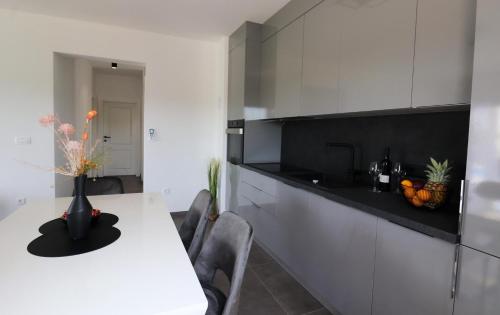 a kitchen with a white counter and a white table at Villa Gemini in Zadar