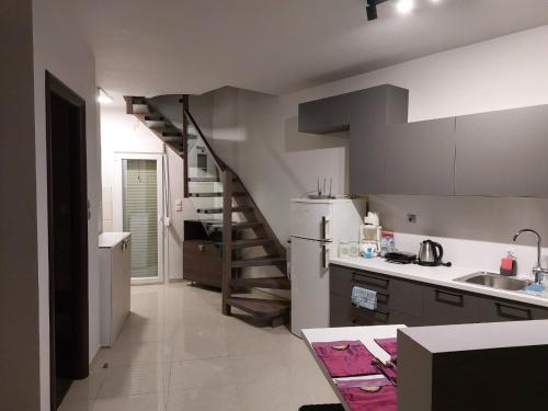 a kitchen with a staircase and a white refrigerator at Ioa Loft in Ioannina