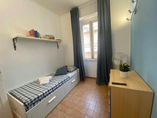 a bedroom with a bed and a desk and a window at Home Romana Centro Nettuno in Nettuno