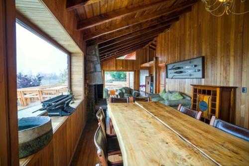 uma sala de jantar com uma grande mesa de madeira e cadeiras em Loma del Viento em Farellones