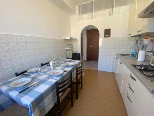 a kitchen with a table with a blue and white table cloth at Home Romana Centro Nettuno in Nettuno