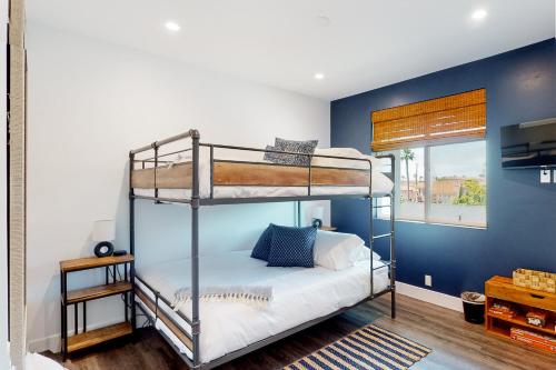 a bedroom with two bunk beds and a blue wall at Seaside Serenity Retreat Inviting condo in Oceanside with rooftop, hot tub, balcony, and ocean views in Oceanside