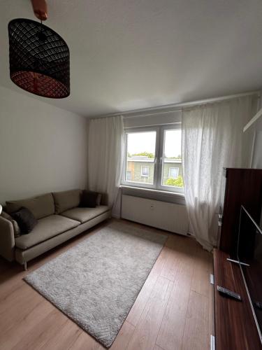 uma sala de estar com um sofá e uma janela em Möblierte Wohnung in Duisburg em Duisburgo