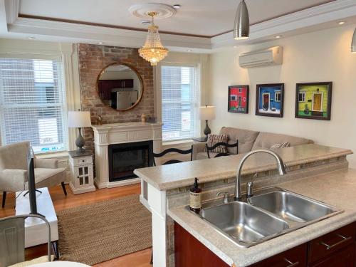 a kitchen and living room with a sink and a fireplace at Water Street and HarborGate Condos & Studios in St. John's