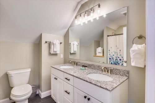 La salle de bains est pourvue de 2 lavabos, de toilettes et d'un miroir. dans l'établissement Village with a View, à Stowe