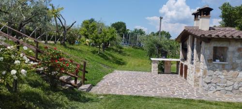 a stone house with a gate and a building at L'angolo degli ulivi in Marcellano