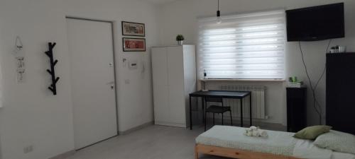 a bedroom with a bed and a table and a window at L'angolo degli ulivi in Marcellano