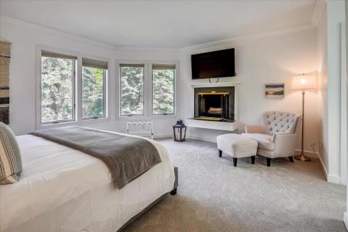 a bedroom with a bed and a chair and a fireplace at Topnotch Retreat in Stowe