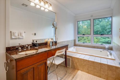 baño con espejo grande, bañera y lavamanos en Topnotch Retreat, en Stowe