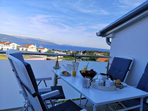 a table with a bowl of fruit on a balcony at Apartman The View Krk in Krk