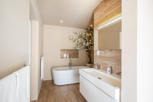a bathroom with a white tub and a sink at Villa Bon Vista Cas Grandi in Willemstad