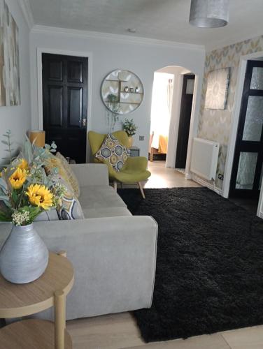 a living room with a couch and a vase of flowers at Station Retreat in Boldon