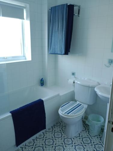 a white bathroom with a toilet and a sink at Station Retreat in Boldon