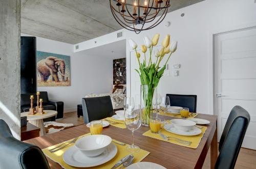 a dining room with a table with a vase of flowers at Les Immeubles Charlevoix - Le 760-406 in Quebec City