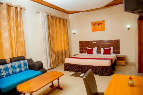 um quarto com uma cama e um sofá num quarto em DANA KIGALI HOTEL em Kigali