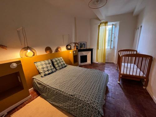 une chambre avec un lit et une chaise dedans dans l'établissement Magnanerie avec piscine en Coeur de village, à Canaules-et-Argentières