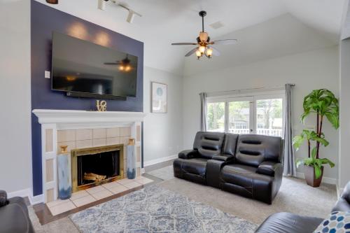 a living room with a black leather chair and a fireplace at Spacious Refuge with Private Pool and Outdoor Bar! in Amherst