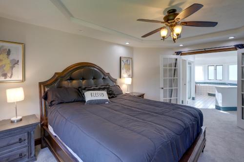 a bedroom with a large bed with a ceiling fan at Spacious Refuge with Private Pool and Outdoor Bar! in Amherst