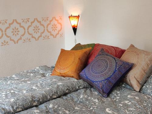 a bed with colorful pillows on top of it at Storchennest mit großem Garten für Urlaubsgäste in Nauen