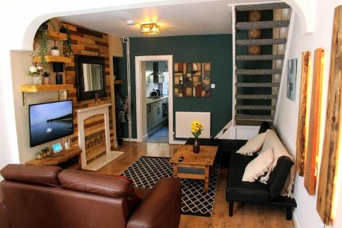 sala de estar con sofá y TV en Stylish & Comfortable House in Swansea, en Morriston