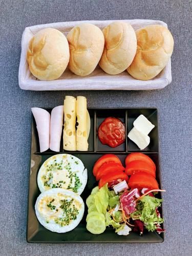 Zwei Teller mit Brötchen und Gemüse standen auf einem Tisch. in der Unterkunft VILLA LIGHTHOUSE - Adults Only - 12plus in Krynica Morska