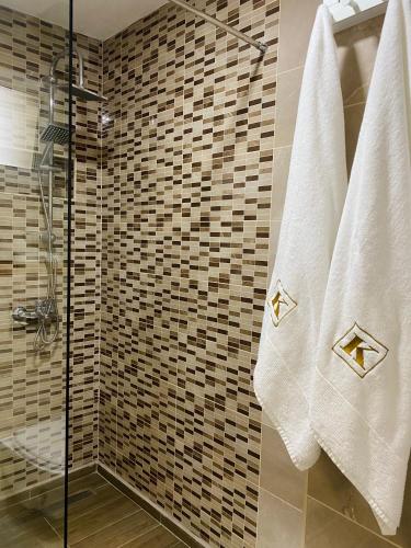 a bathroom with a shower with white towels at Apartment in Shtip in Štip