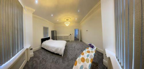 een slaapkamer met een wit bed en een raam bij Luxury Apartment with a jacuzzi in Wolverhampton