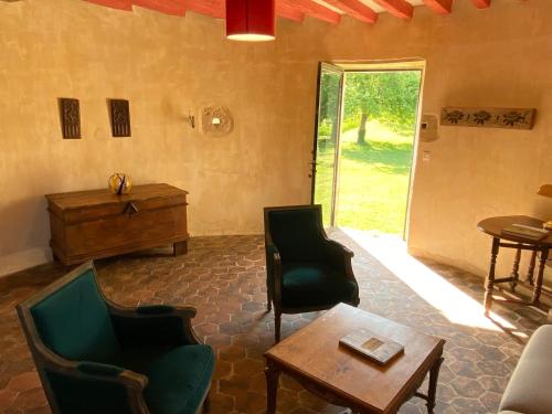 a living room with chairs and a table and a door at Tour du manoir de Boiscorde in Rémalard
