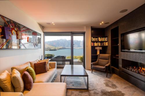 a living room with a couch and a fireplace at Aspen Grove by Sotheby's Luxury Rental Homes in Queenstown