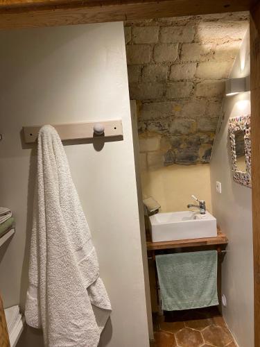 La salle de bains est pourvue d'un lavabo et d'une serviette blanche. dans l'établissement Tour du manoir de Boiscorde, à Rémalard