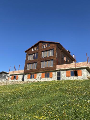 a building on top of a grassy field at Karester Villa Apart in Uzungöl