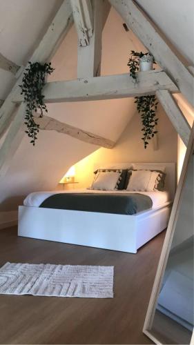 une chambre avec un lit blanc dans un grenier dans l'établissement Charmant Duplex - Parking inclus - Au bord de l'Eure, à Chartres