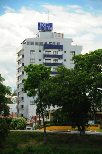 a hotel with a sign on top of a building at Hotel Vila Rica Flat in Resende