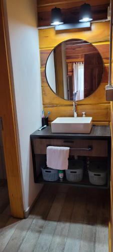 y baño con lavabo y espejo. en Cabaña los ciruelos en Santa Rosa de Calamuchita