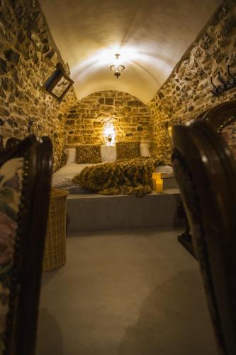 a bedroom with a bed in a room with stone walls at Villa Porta Qeparo in Qeparo