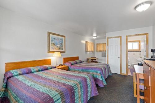 エリーにあるRiviera Motelのベッド2台とキッチンが備わるホテルルームです。