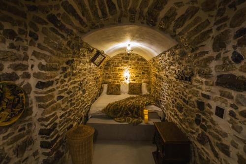 a room with a bed in a stone wall at Villa Porta Qeparo in Qeparo